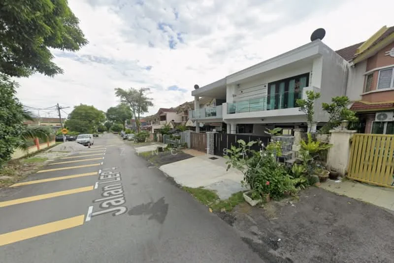 Exterior type: linked terrace house; features: grey painted facade, recessed balconies, glass railing on balcony, manicured lawn, paved walkway, mature trees, fence with gate, two-storey structure, street view with road markings, adjacent houses visible; style: modern.