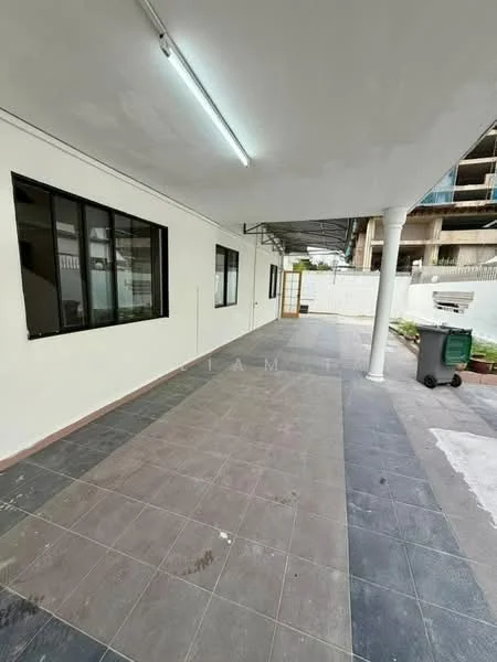 Exterior features: covered patio area, grey tiled flooring, white painted walls, large windows, outdoor lighting, drainage system visible, green waste bin, open space, surrounding wall, concrete support columns; style: modern.