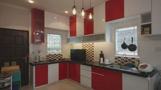 Kitchen features: red and white cabinetry, black countertop, ceramic tile backsplash with brown and white pattern, built-in oven, stainless-steel sink, chrome pull-down faucet, recessed downlights, hanging pendant lights, window with decorative grille, floor tiles, kitchen appliances, open shelving, pantry storage; style: modern.