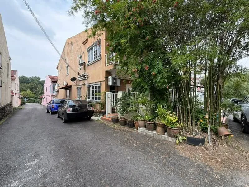 Exterior type: linked terrace house; features: two-storey building, painted facade in peach, greenery with potted plants, bamboo plants, driveway with gravel surface, two parked cars, surrounded by residential area, visible air conditioning units; style: modern.