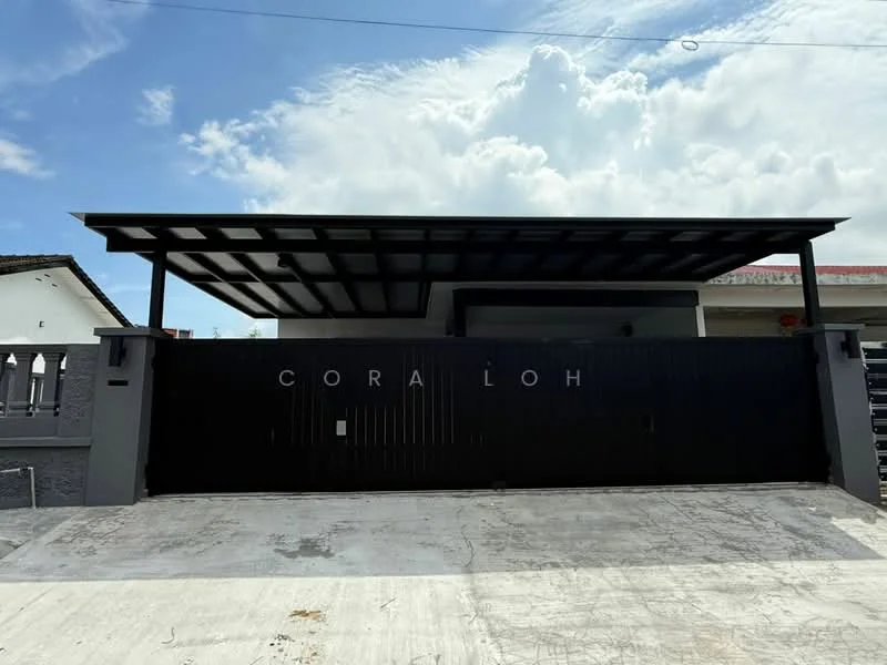 Exterior type: detached bungalow; features: black painted facade, flat roof with overhang, concrete driveway, metal gate, nameplate with 'CORA LOH', surrounding wall, clear blue sky, clouds in background; style: modern.