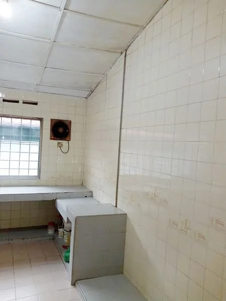 Room features: white tiled walls, white ceiling tiles, window with grid pattern, wall-mounted fan, light-colored floor tiles, countertop with storage underneath, open space layout; style: minimalist.