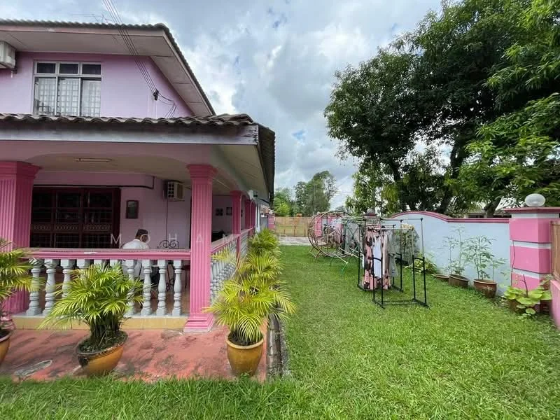 Exterior type: detached bungalow; features: pink painted facade, single-storey, manicured lawn, potted plants, covered porch with railing, outdoor clothes drying rack, surrounded by greenery, driveway, fenced yard; style: traditional.