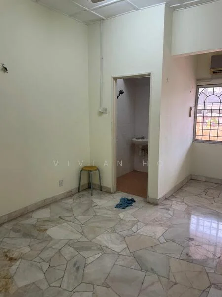 Room features: marble flooring, white painted walls, window with metal grille, single-basin sink, shower head, light fixture on ceiling, chair, towel on floor.