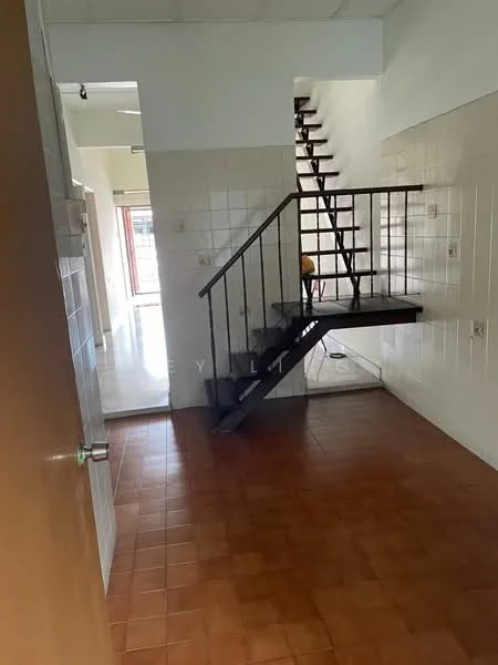 Room features: brown tiled flooring, white tiled walls, metal staircase, open layout, natural light from windows, door leading to another room, high ceiling, wall-mounted light fixture.
