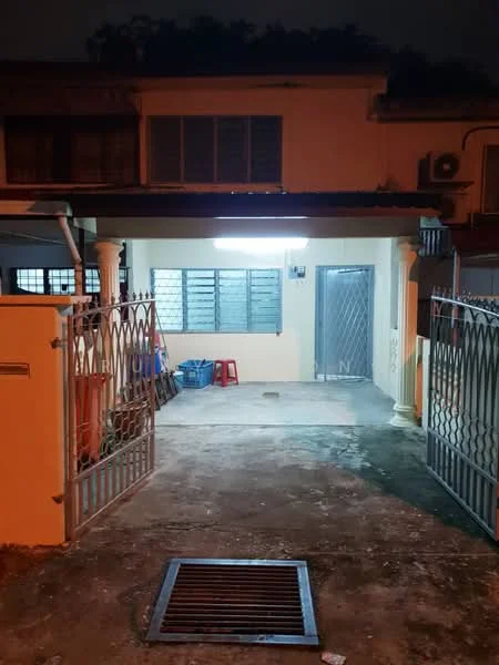 Exterior type: linked terrace house; features: gate with decorative metalwork, concrete driveway, porch area with overhead lighting, front entrance with security door, windows with metal grilles, exposed concrete flooring, outdoor seating area, nighttime lighting, surrounding greenery; style: modern.