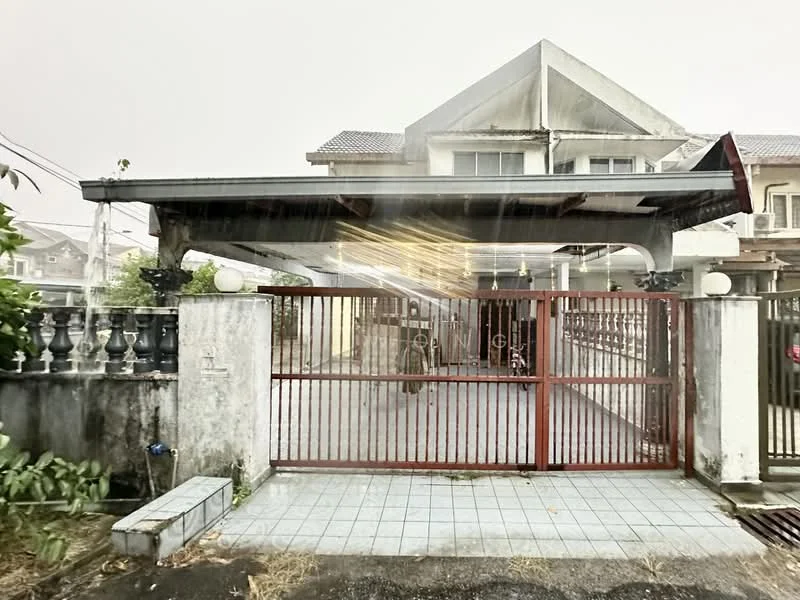 Exterior type: semi-detached house; features: red metal gate, covered car porch, white tiled flooring, fenced perimeter, manicured landscaping, two-storey structure, gabled roof, exposed concrete walls, balcony on upper floor, outdoor lighting fixtures; style: modern.