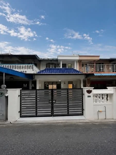 Exterior type: linked terrace house; features: metal gate with horizontal slats, white painted facade, blue tiled roof, balcony with railing, front garden area, driveway, two-storey structure, visible windows with grills; style: modern.
