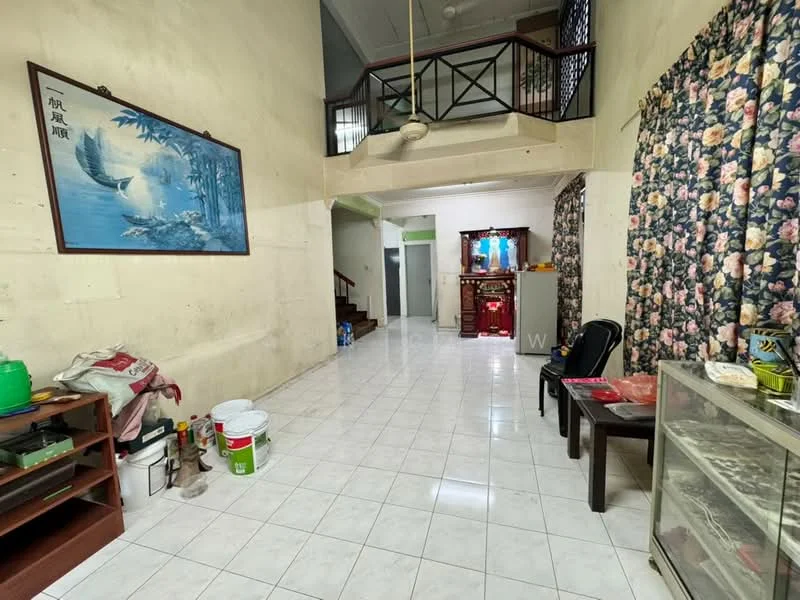 Living features: white painted walls, ceramic tile flooring, high ceiling, large window with floral curtains, wooden staircase, decorative wall art, open layout, built-in shelving unit, plastic chairs, glass display cabinet, various paint buckets.