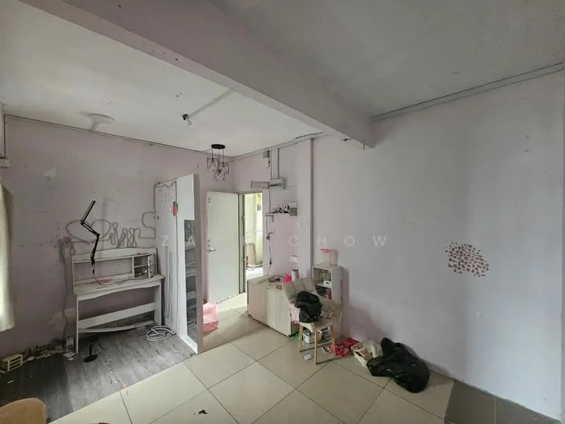 Room features: light grey painted walls, white ceiling, tile flooring, exposed ceiling beams, small chandelier, built-in shelving unit, open doorway leading to another room, scattered personal items on the floor.