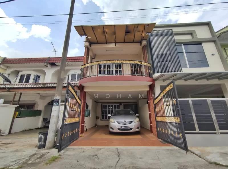 Exterior type: linked terrace house; features: two-storey structure, balcony with decorative railing, tiled driveway, car porch with space for one vehicle, front garden area, exterior wall with cream and red accents, large windows with metal grilles, roof overhang, paved walkway, surrounding residential area; style: modern.