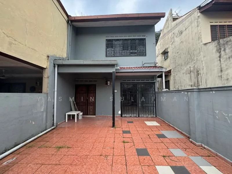 Exterior type: semi-detached house; features: grey painted facade, red tiled roof, front porch area, paved walkway, security grille at entrance, manicured lawn, fenced perimeter, two main entrance doors; style: modern.
