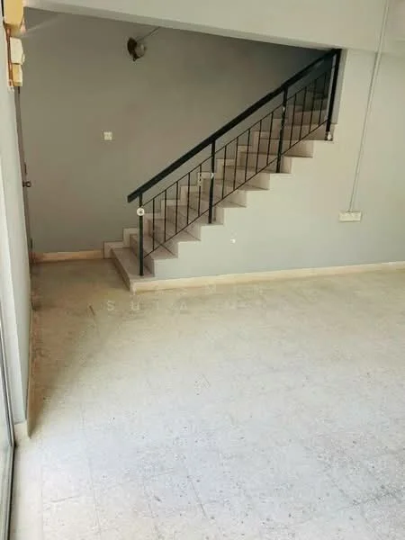 Room features: grey painted walls, concrete flooring, staircase with metal railing, light fixture on wall, open space layout; style: modern.