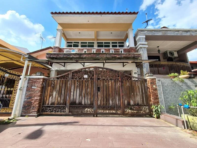 Exterior type: detached bungalow; features: brick facade, wooden gate, two-storey structure, cross on top of building, balcony on upper floor, manicured landscaping, paved driveway, gated entrance, visible air conditioning unit, decorative stone cladding, roof with overhang, windows with grills; style: modern.