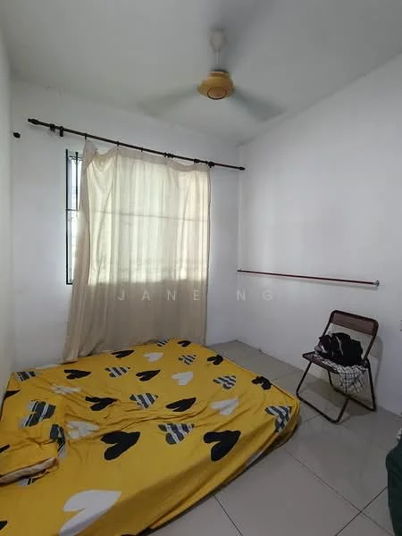 Bedroom features: white painted walls, tile flooring, ceiling fan, window with sheer curtains, bed with yellow and black heart-patterned bedding, folding chair, clothes rack, wall-mounted rod.