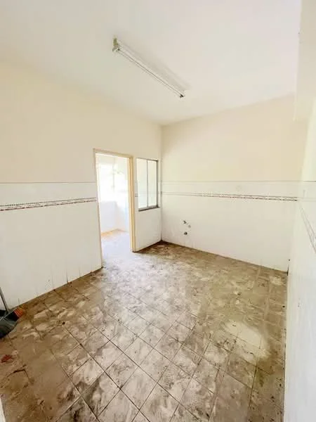 Room features: white painted walls, tile flooring, window with glass panes, doorway leading to another room, ceiling light fixture, wall tiles with decorative border, plumbing fixtures visible on wall.