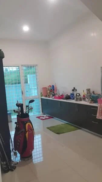 Room features: white painted walls, high ceiling, glossy tile flooring, kitchen cabinetry in dark wood, countertop with sink, kitchen appliances visible, golf clubs and bag, green area rug, sliding glass door, window with security bars, decorative items on countertop; style: modern; view: garden.