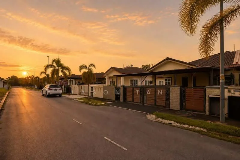 Exterior type: linked terrace house; features: single-storey, pitched tile roof, cream painted facade, stone cladding, manicured lawn, palm trees, driveway with interlocking pavers, gated entry, sunset view, street lighting, sidewalk; style: modern.