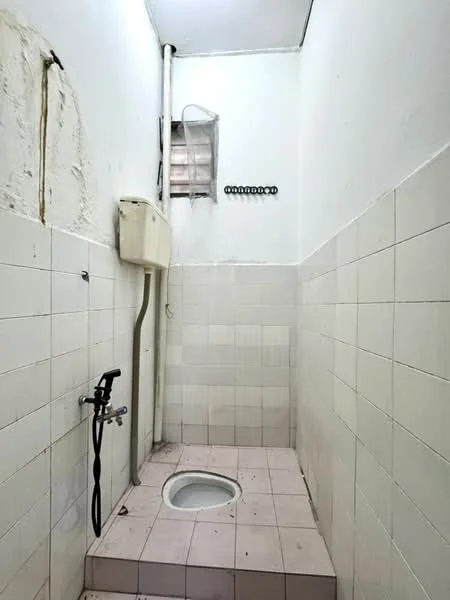 Bathroom features: white tiled walls, light grey tiled flooring, squat toilet, shower area with wall-mounted faucet, exposed plumbing, small window for ventilation; style: minimalist.