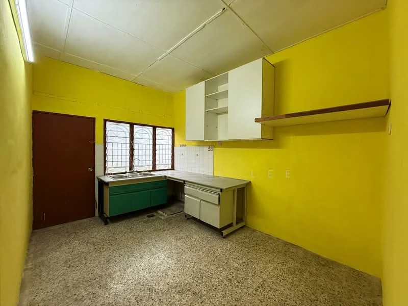 Kitchen features: yellow painted walls, grey countertop, green base cabinets, white upper cabinets, open shelving, single-bowl stainless-steel sink, wall-mounted faucet, window with grid pattern, tile backsplash, flooring with speckled pattern, door to exterior.