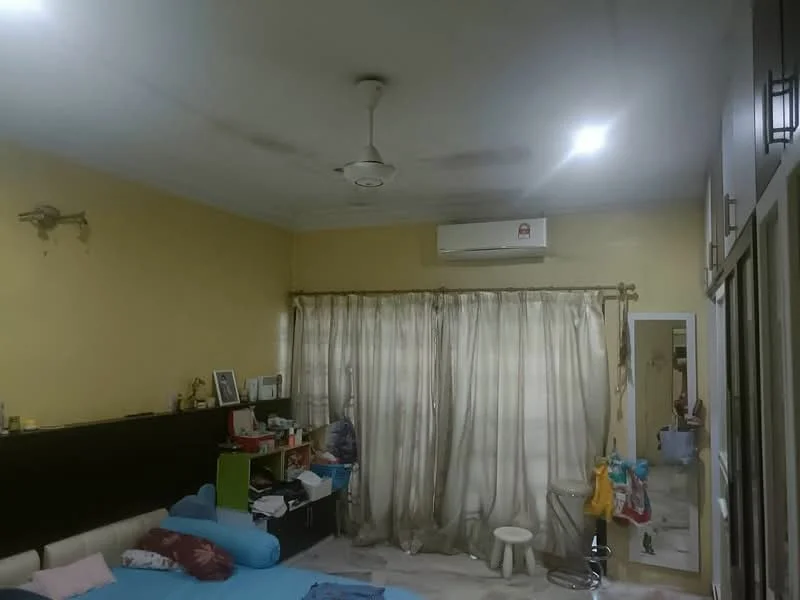 Room features: yellow painted walls, ceiling fan, 1 wall-mounted split AC, curtains, flooring with light-colored tiles, built-in wardrobe, mirror, decorative wall sconce, bed with blue bedding, small stool, various items on furniture.