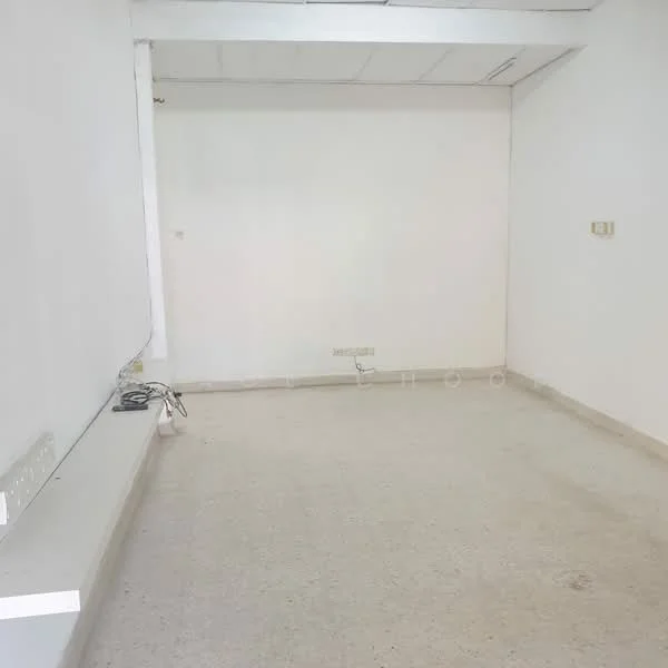 Room features: white painted walls, plain ceiling, concrete flooring, no visible furniture, single electrical outlet, minimal natural light; style: minimalist.