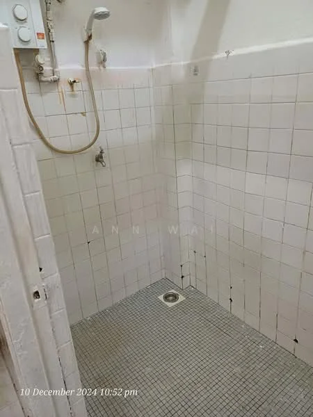 Bathroom features: white tiled walls, grey mosaic tile flooring, shower head, handheld shower, shower valve, drain, wall-mounted water heater.