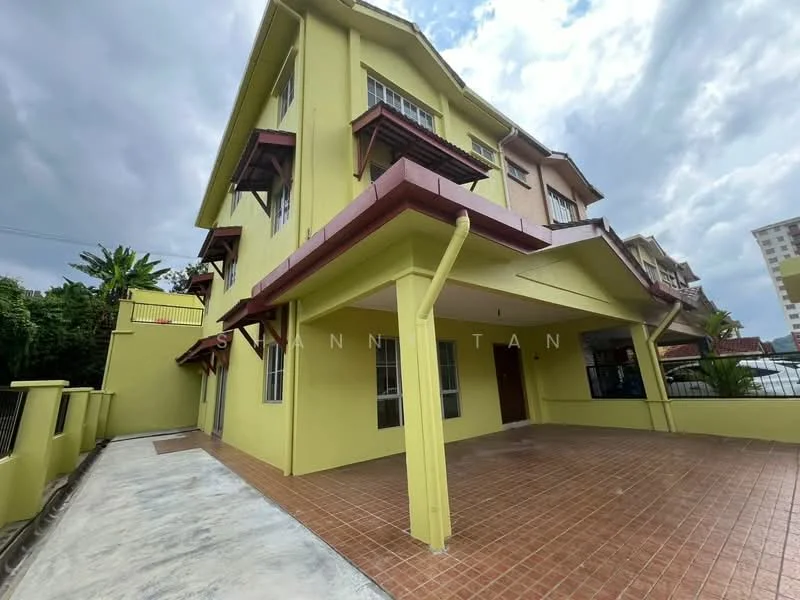 Exterior type: semi-detached house; features: yellow painted facade, red tiled roof, two-storey structure, covered car porch, manicured landscaping, paved driveway, balconies with wooden railings, large windows, front entrance door, surrounded by greenery; style: modern.