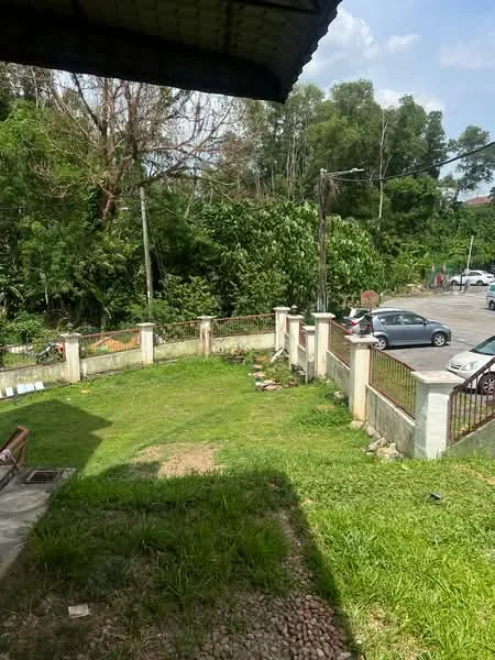 Exterior features: manicured lawn, fenced perimeter, concrete boundary wall, gravel pathway, surrounded by greenery, parking space visible, paved driveway, trees in background.