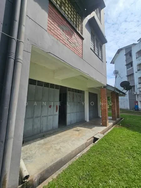 Exterior type: low-rise apartment block; features: grey painted facade, red brick accents, ground floor with covered porch, metal grilles on windows, concrete flooring, lawn area in front, satellite dish visible, adjacent to other apartment buildings; style: modern.