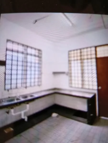 Kitchen features: white painted walls, grey tiled flooring, black countertop, double-bowl stainless-steel sink, chrome faucet, wall-mounted shelves, window with metal grilles, door with wooden finish.