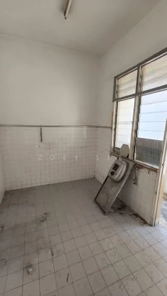 Room features: white tiled walls, grey tiled flooring, single window with metal frame, exposed electrical wiring, corner sink, no visible cabinetry, minimal natural light, clean but empty space.