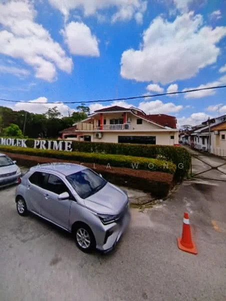 Exterior type: detached bungalow; features: two-storey building, red tiled roof, white painted facade, large front yard, manicured hedges, driveway, surrounding greenery, clear blue sky, parking area, street view, signage with 'MOLEK PRIME'; style: modern.