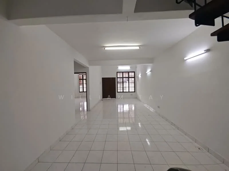 Room features: white painted walls, glossy white tile flooring, fluorescent ceiling lights, large windows with grid pattern, open layout, staircase visible in the corner, no visible furniture or decor; style: modern.