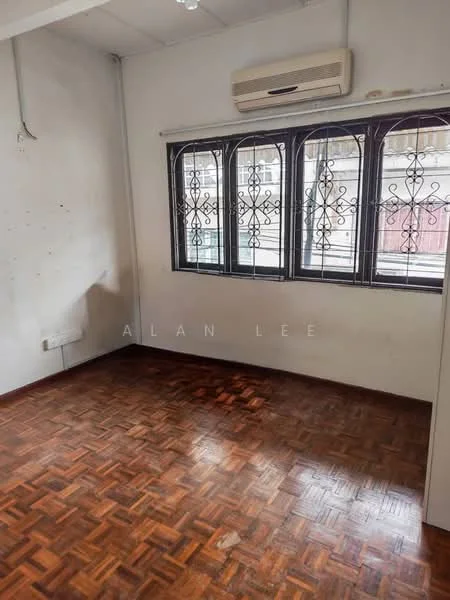 Room features: wooden parquet flooring, white painted walls, 1 wall-mounted split AC, black metal grille windows, natural light from windows.
