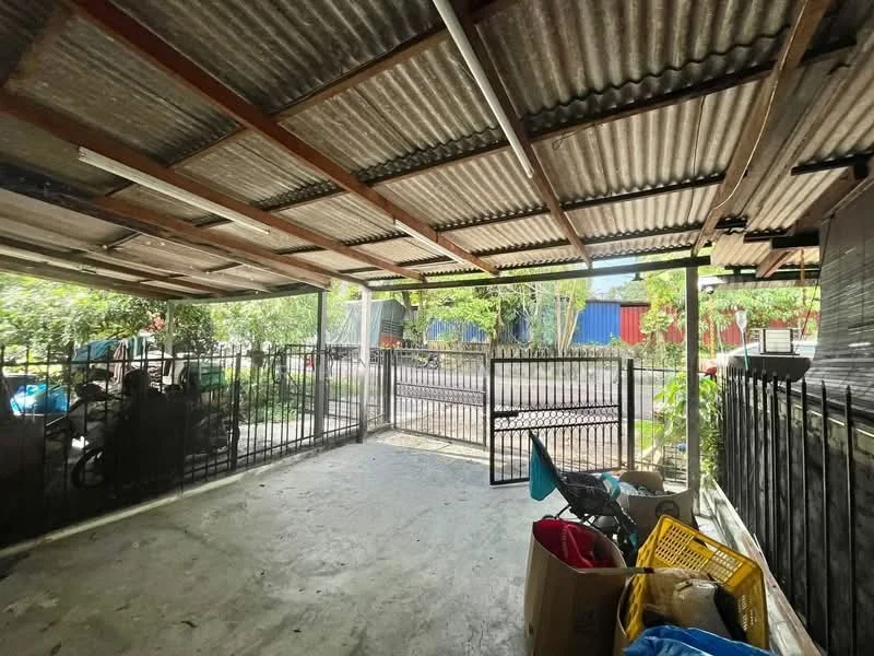 Exterior type: car porch; features: metal roof, concrete flooring, fenced perimeter, gated entry, surrounded by greenery, outdoor space for parking, open-air structure; style: minimalist.