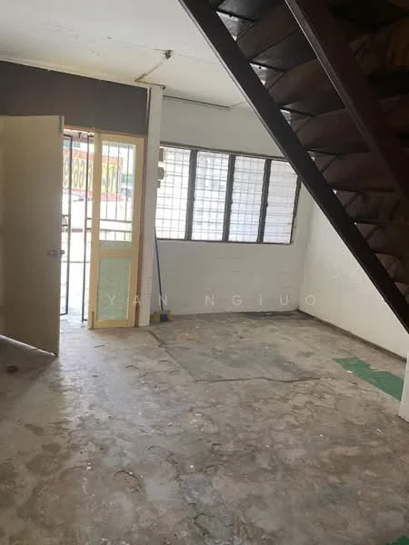 Room features: concrete flooring, white walls, staircase with wooden steps, door leading outside, large windows with grid pattern, unfinished interior, cleaning equipment visible, open layout.