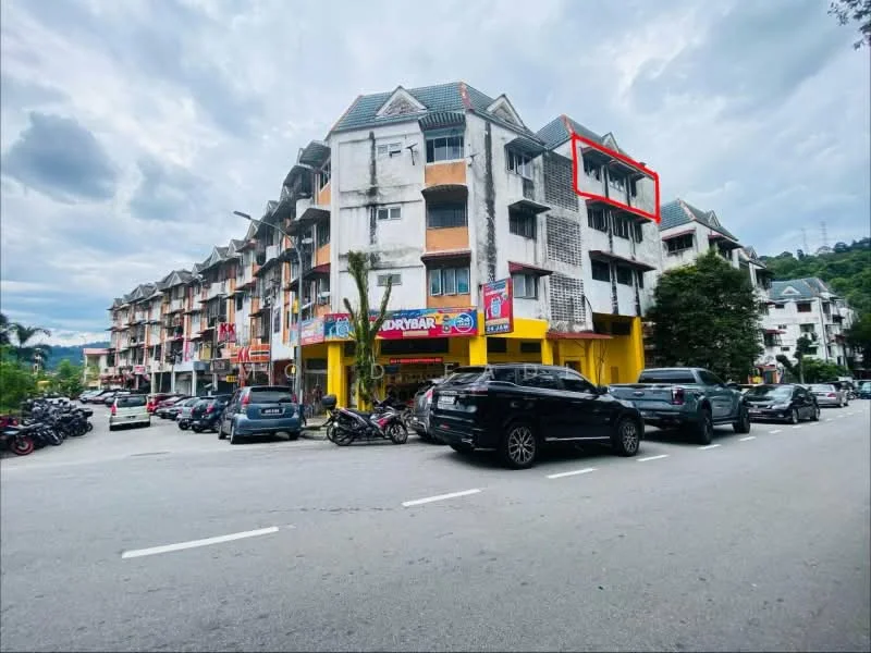 Exterior type: low-rise apartment block; features: white painted facade, grey tiled roof, balconies on upper floors, ground floor retail space, multiple parking spaces, surrounding greenery, street view with vehicles, signage on retail units; style: modern.