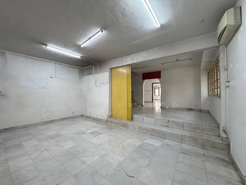 Room features: white painted walls, marble tile flooring, exposed ceiling with fluorescent lights, air conditioning unit, large window with metal grille, step-up area, neutral color scheme.