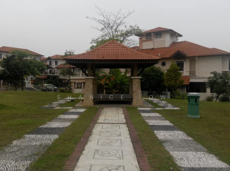 Exterior type: landscape garden; features: gazebo with tiled roof, stone-clad base, manicured lawn, paved walkway with decorative stones, surrounding greenery, residential buildings in background; style: tropical-modern.