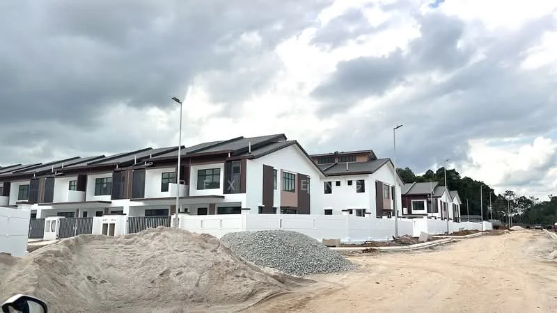 Exterior type: linked terrace house; features: white painted facade, brown accent panels, flat roof, two-storey, manicured landscaping, paved driveway, street lighting, surrounded by construction site; style: modern.