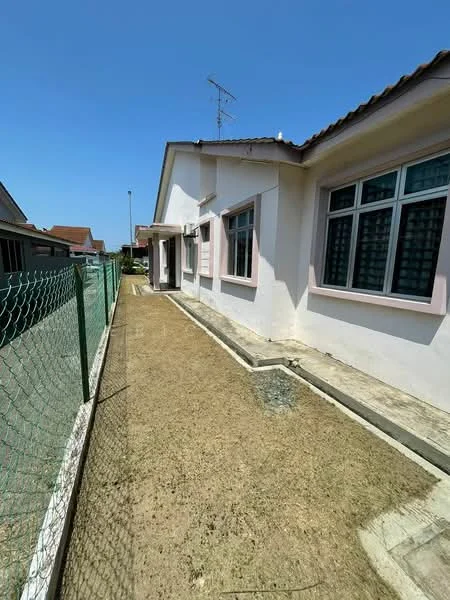 Exterior type: detached bungalow; features: white painted facade, single-storey, fenced yard with chain-link fence, concrete pathway, landscaped area with bare soil, gabled roof, windows with grid pattern, side entrance door; style: modern.