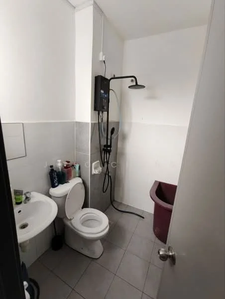 Bathroom features: white toilet, sink with chrome faucet, shower with wall-mounted showerhead, grey tiled walls, light grey floor tiles, shower hose, plastic storage bin, toiletries on shelf.