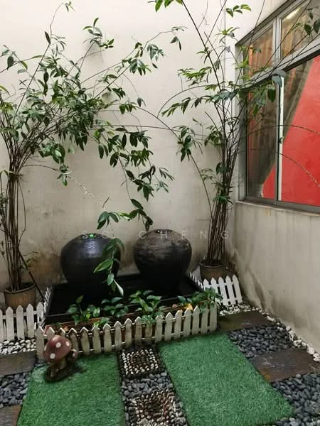 Exterior type: landscape garden; features: decorative stone pathway, two large decorative water feature bowls, green foliage plants, white picket fence, artificial grass patches, pebbled ground cover, wall with painted red accent, indoor garden setting; style: modern.