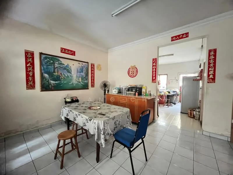 Dining features: white painted walls, tile flooring, ceiling light, dining table with tablecloth, wooden chair, blue upholstered chair, wall-mounted fan, decorative wall art, Chinese character decorations; style: traditional. Kitchen features: wood cabinetry, stainless-steel fridge, kitchen counter, open layout to dining area; style: traditional.