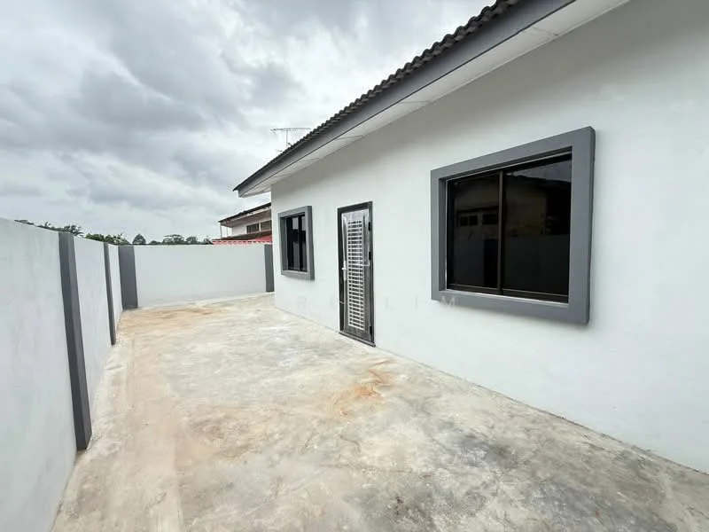 Exterior type: detached bungalow; features: white painted facade, grey window frames, single-storey, concrete flooring, fenced perimeter, sliding security door, gutter along the roof, roof overhang, manicured landscaping, open outdoor space; style: modern.