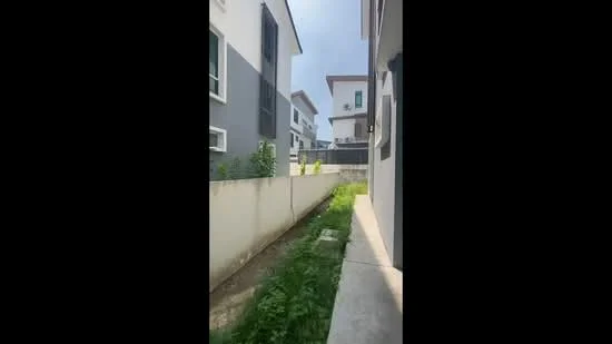 Exterior type: linked terrace house; features: grey painted facade, white painted facade, two-storey structure, narrow pathway, landscaped area with grass, fencing along the property, windows with green frames, gutter along the roofline; style: modern.