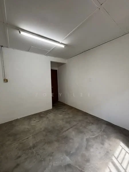 Room features: white painted walls, concrete flooring, fluorescent ceiling light, doorway leading to another room.