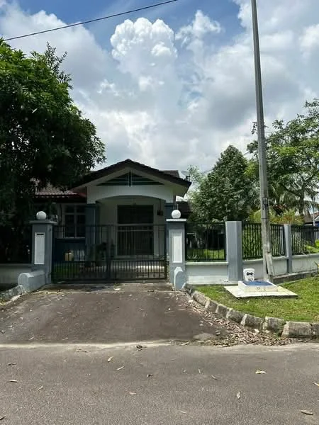 Exterior type: detached bungalow; features: white painted facade, gated entrance with metal fence, manicured lawn, mature trees, paved driveway, front porch with roof, single-storey, surrounded by greenery; style: traditional.