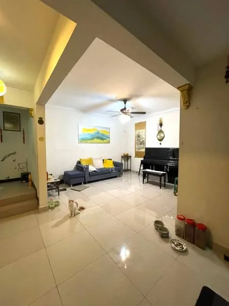 Living features: white painted walls, glossy tile flooring, 5-blade ceiling fan with light, sofa in navy blue, yellow throw pillows, framed artwork on wall, piano, side table, decorative wall clock, cat food bowls, pet food storage containers; style: modern.